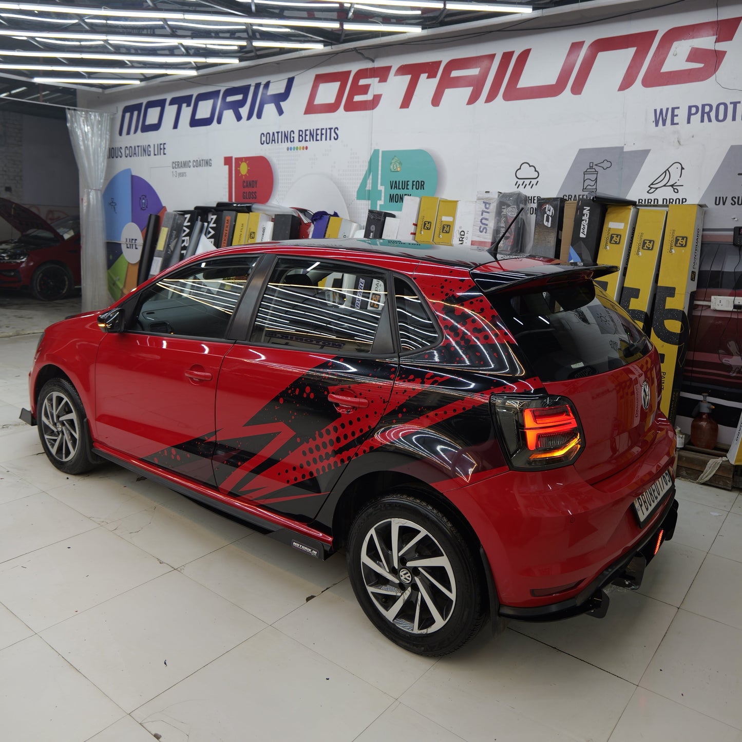 Stylish red hatchback with abstract hatchback car side graphics showcasing a sleek design at Motorik Detailing
