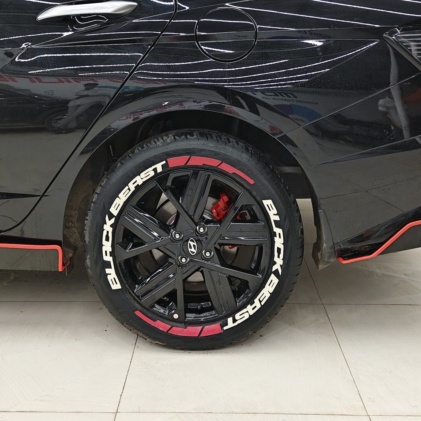 BlackBeast tyre Stickers on a sleek black car with custom wheels and red brake calipers