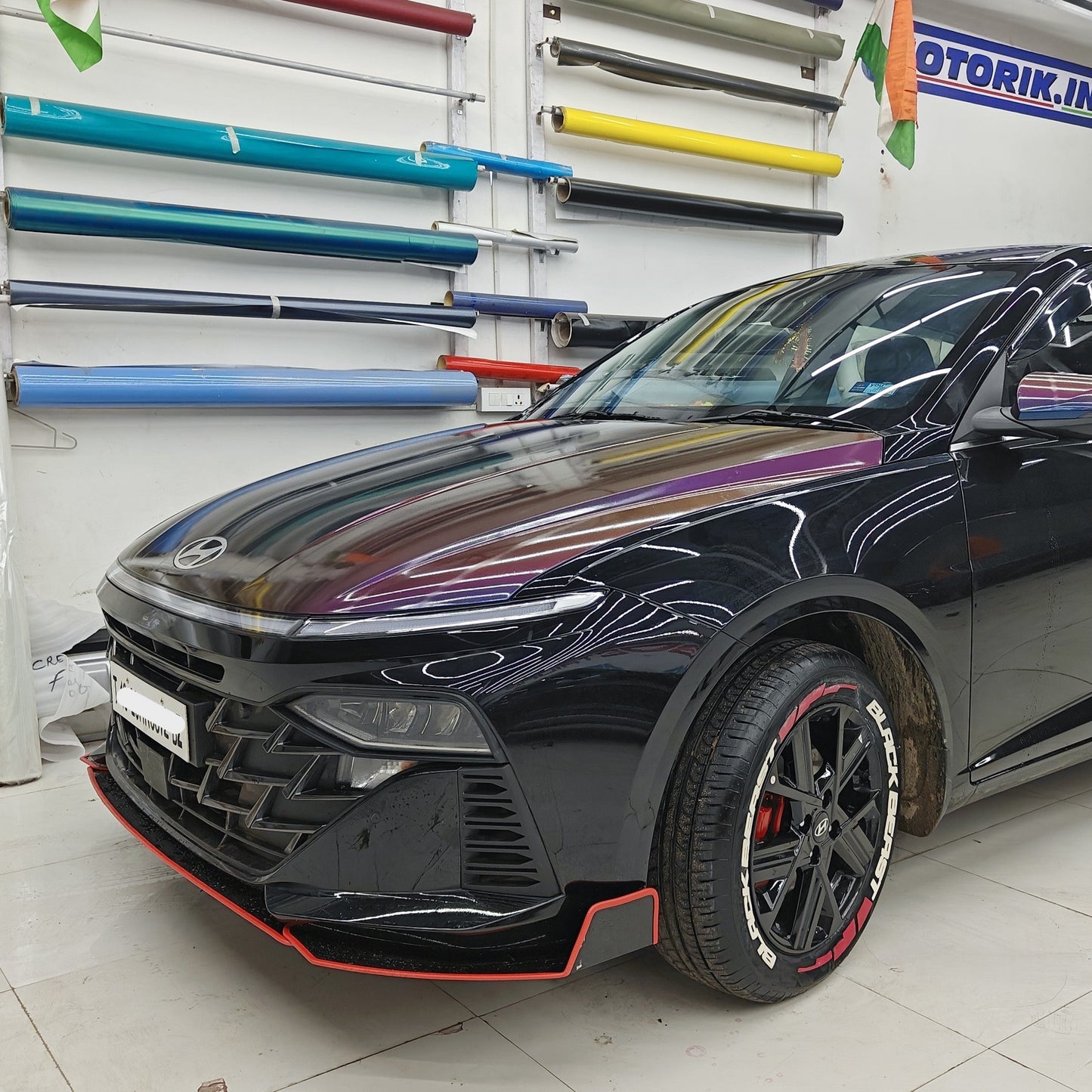 Motorik Detailing Black Car with Stylish Car skirtings and side splitters in Modern Showroom