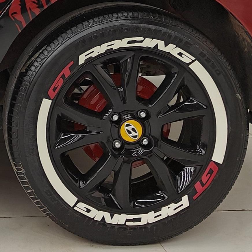 GT Racing tire stickers on a black alloy wheel with red brake calipers for a sporty look