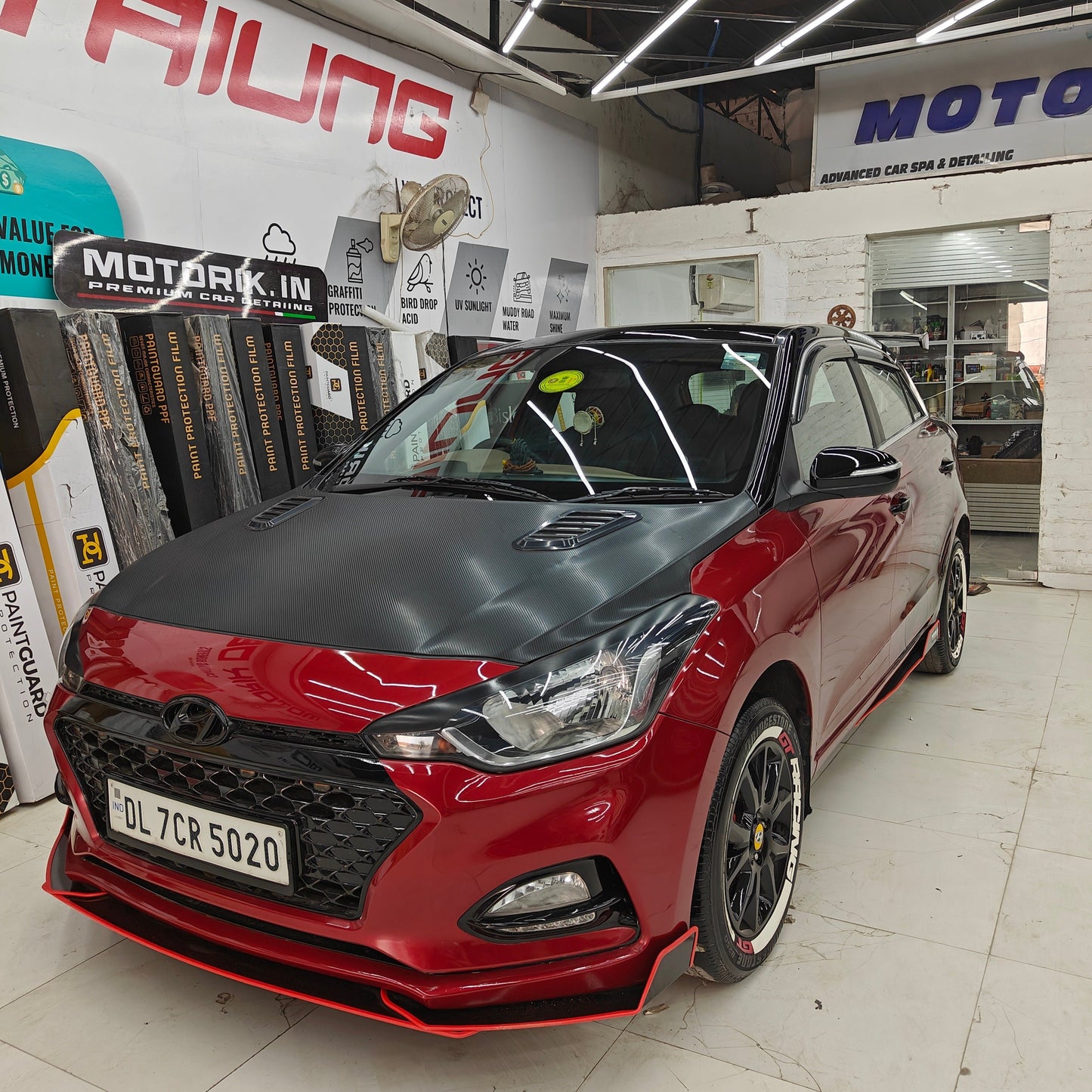 Stylish GT Racing tire stickers on a modified red Hyundai car, showcasing sporty detailing
