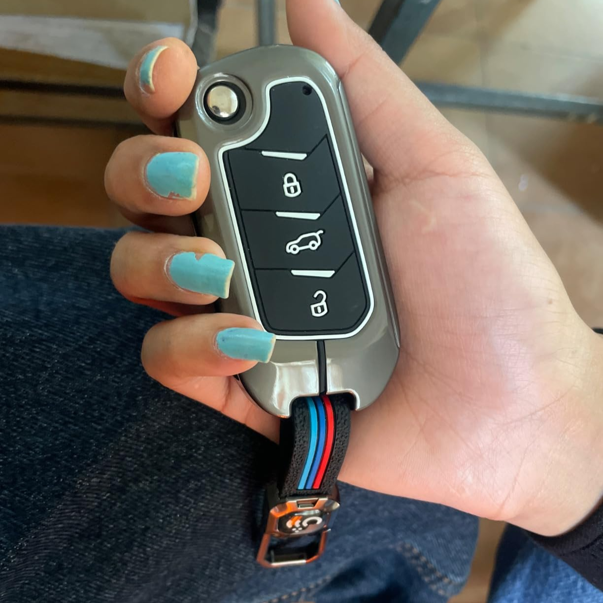 Metal car key cover Mahindra in hand with four buttons and stylish design for protection