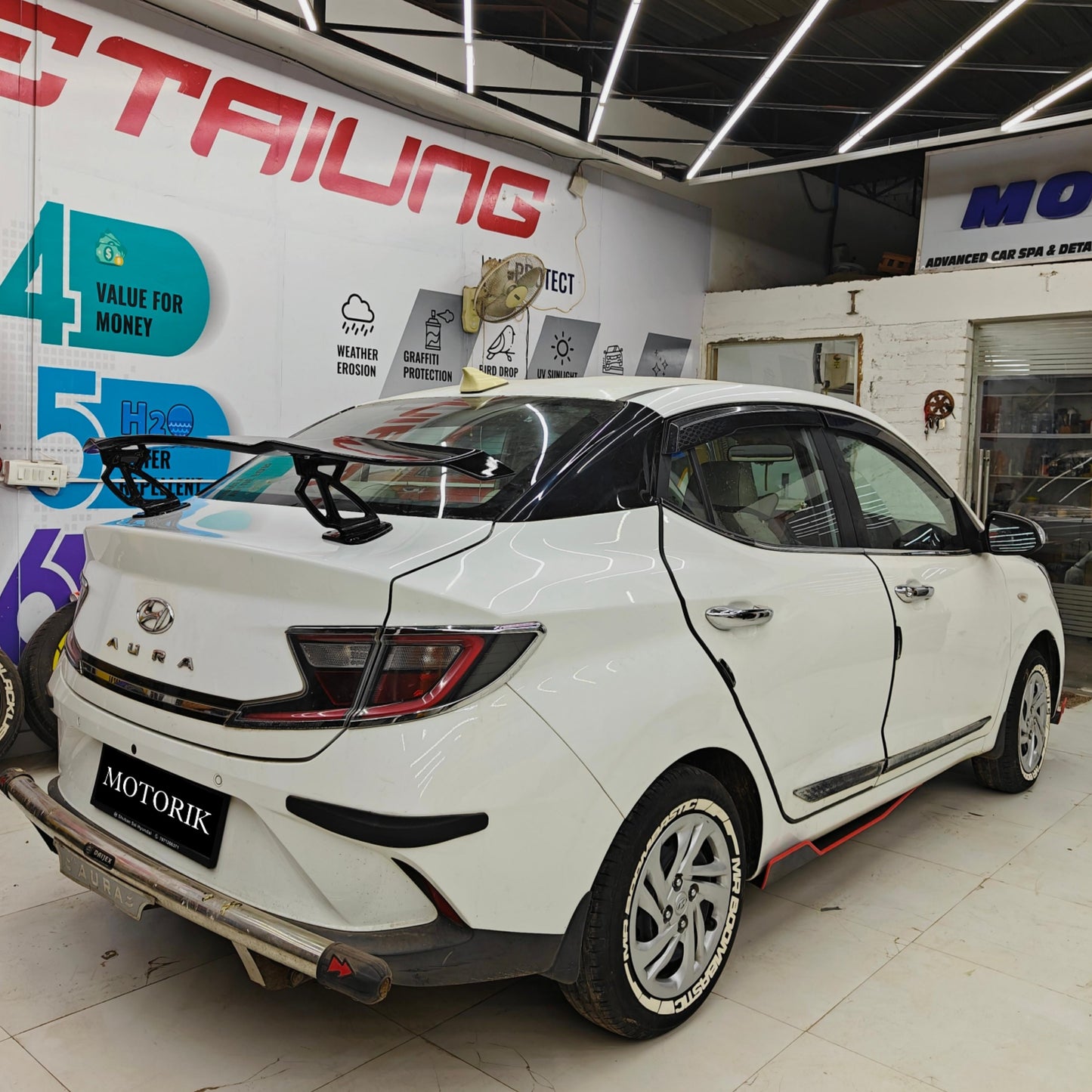 Custom car spoilers for sedans, showcasing a sleek white sedan with a sporty rear wing by Motorik Detailing