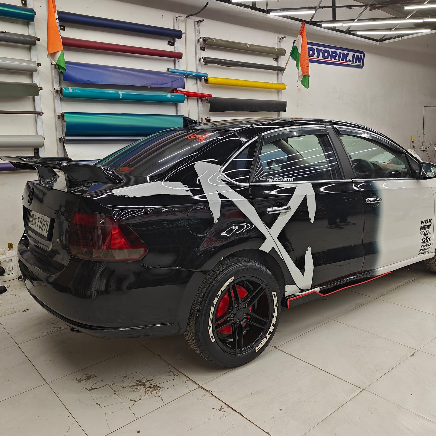 Defaulter tyre sticker on a sleek black and white car with a modern design from Motorik Detailing