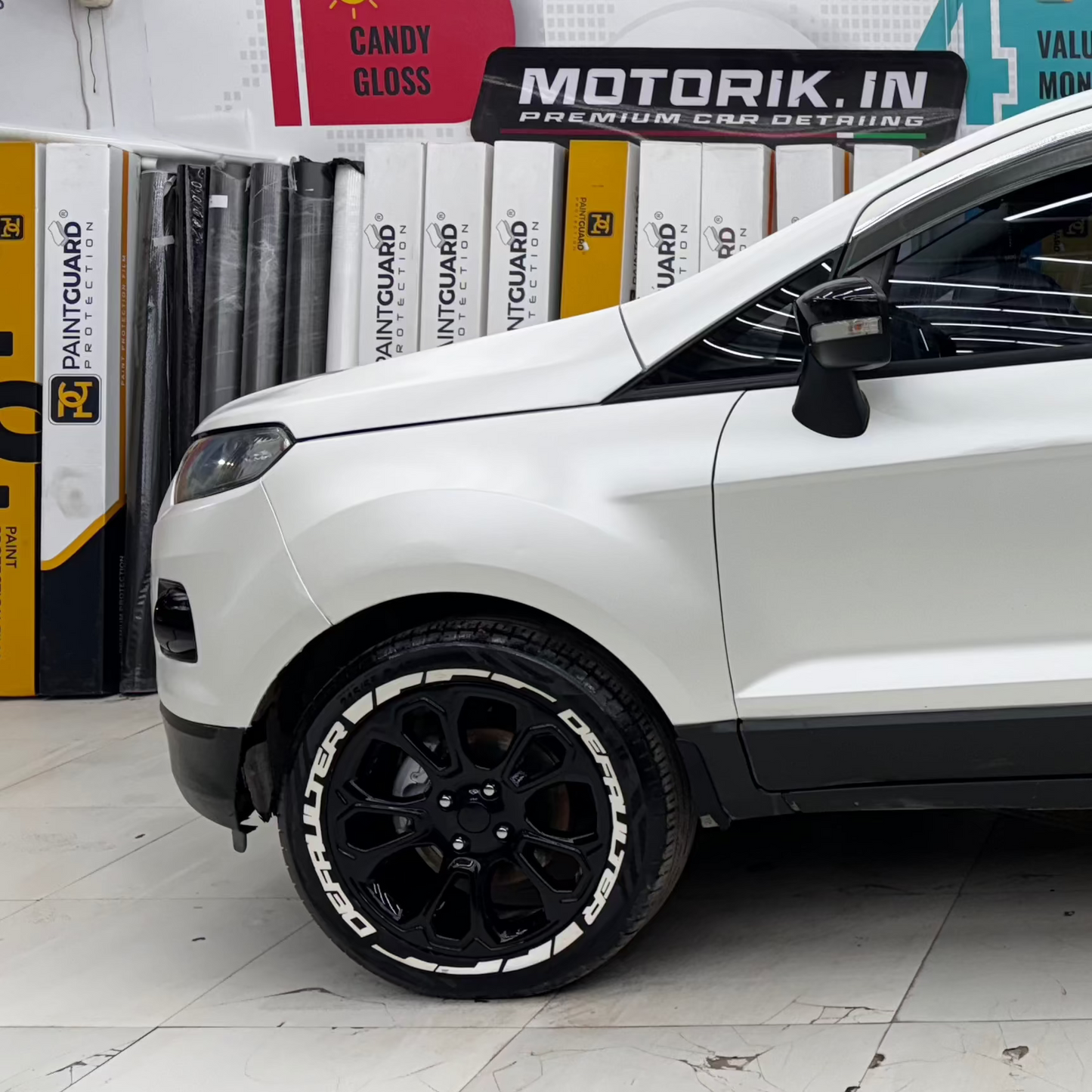 White compact SUV featuring DEFAULTER Tyre Stickers on black alloy wheels for a sporty look