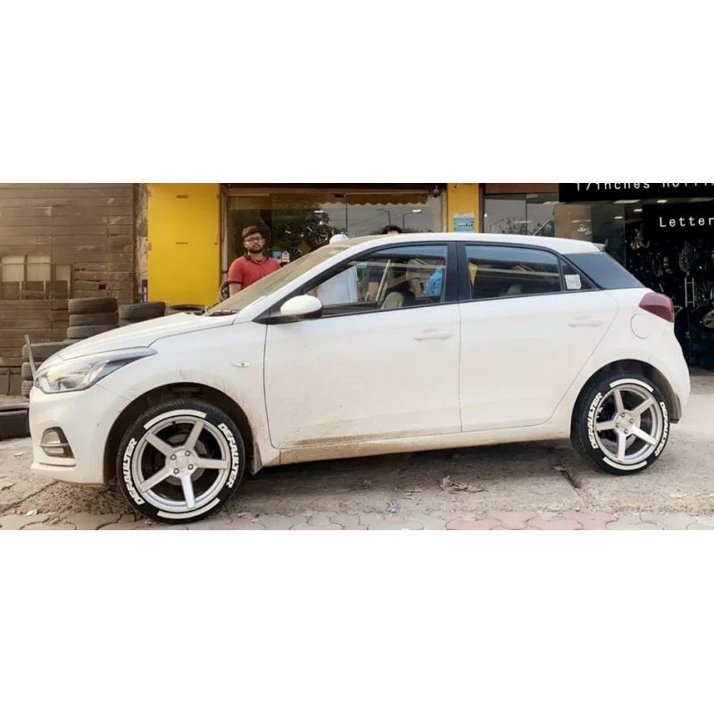 White car with shiny rims fitted with Motorik DEFAULTER tyre stickers for a stylish look