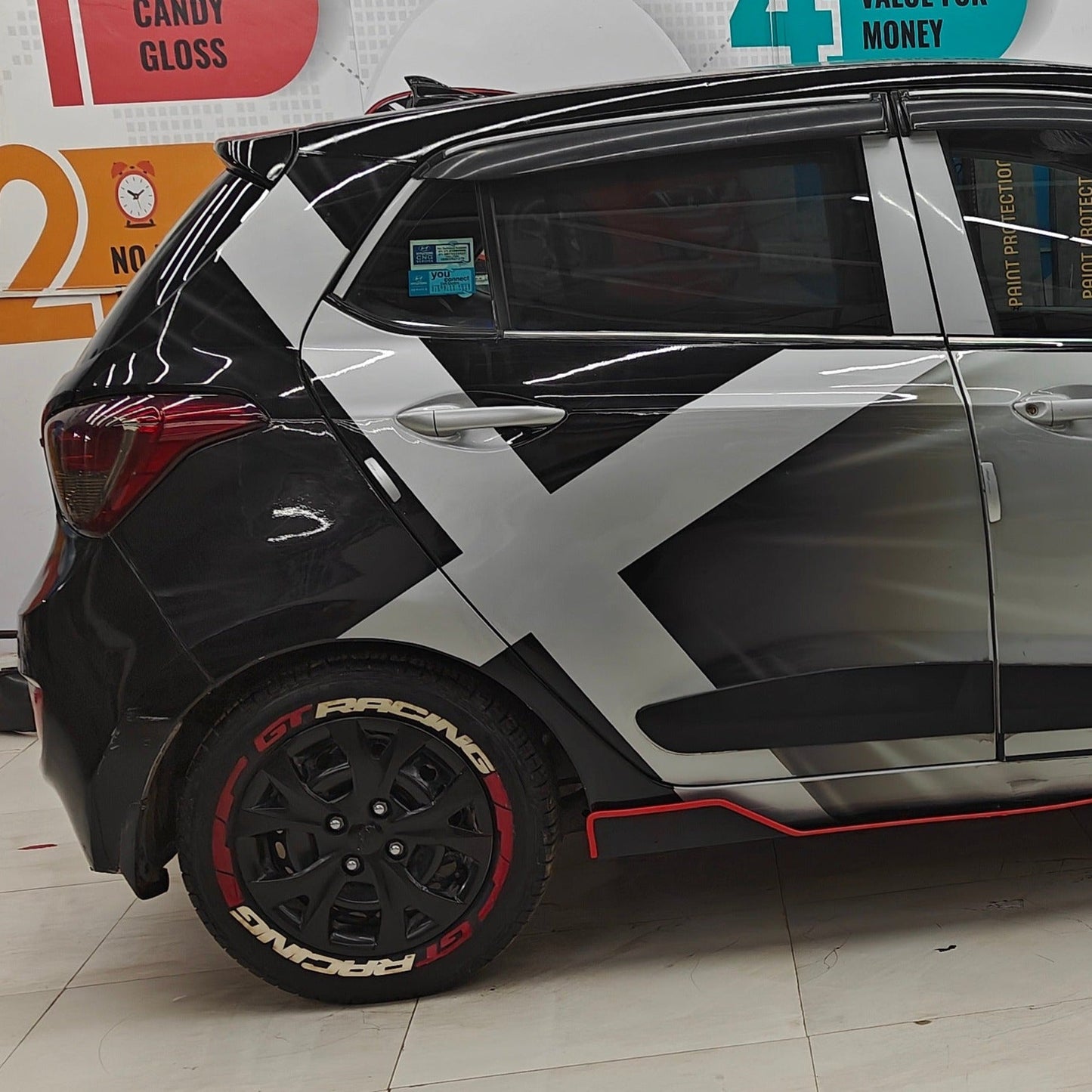Stylish car with GT racing tire stickers with gun strips enhancing its sporty look at Motorik Detailing shop