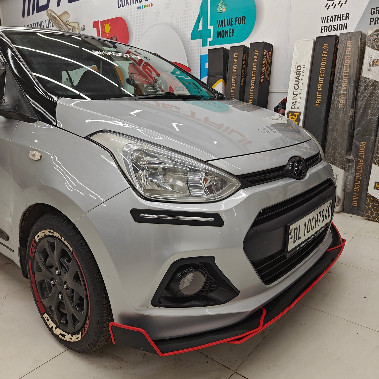 Car with GT racing tire stickers with gun strips showcased in a detail shop setting