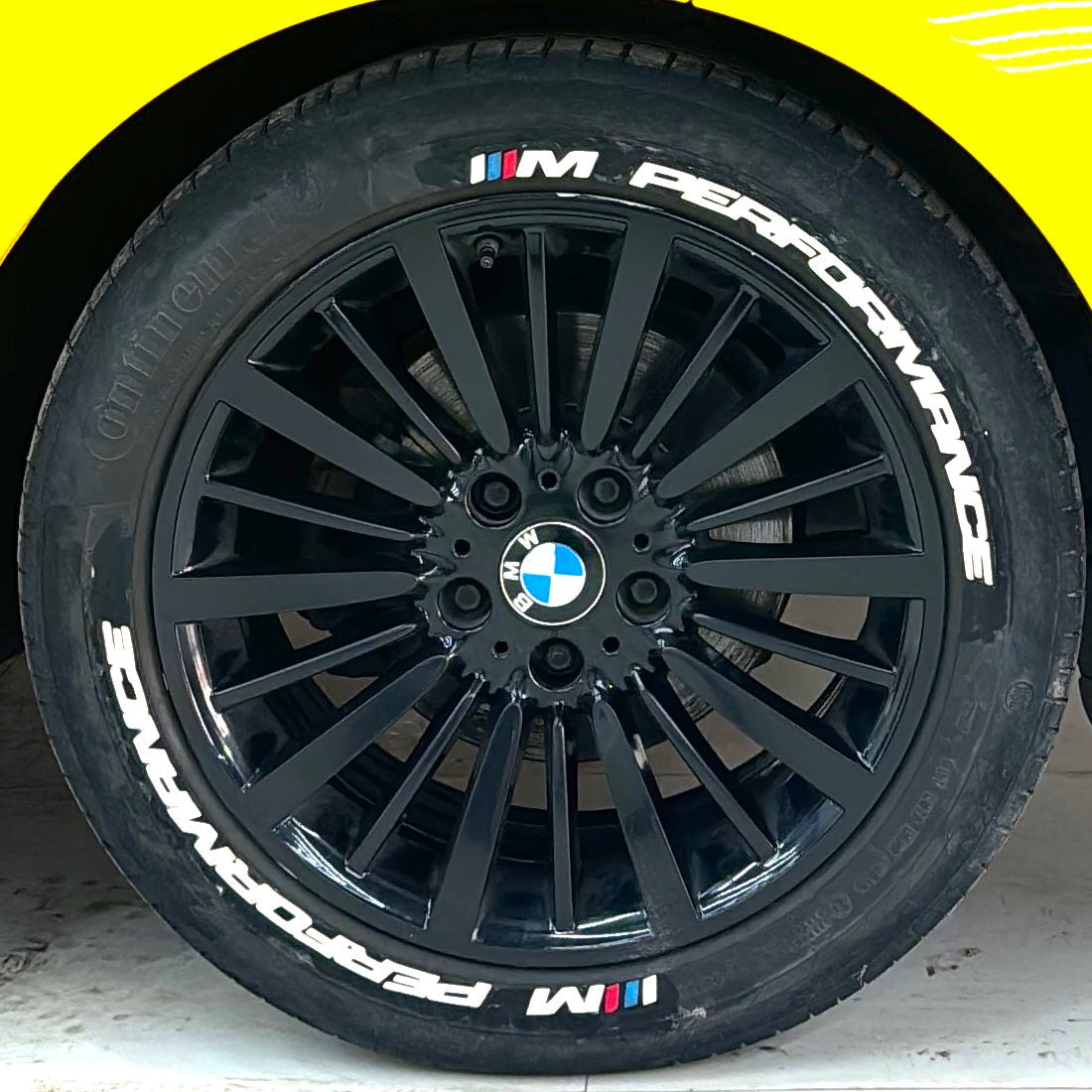 M Performance tire stickers displayed on stylish black alloy wheels of a BMW vehicle