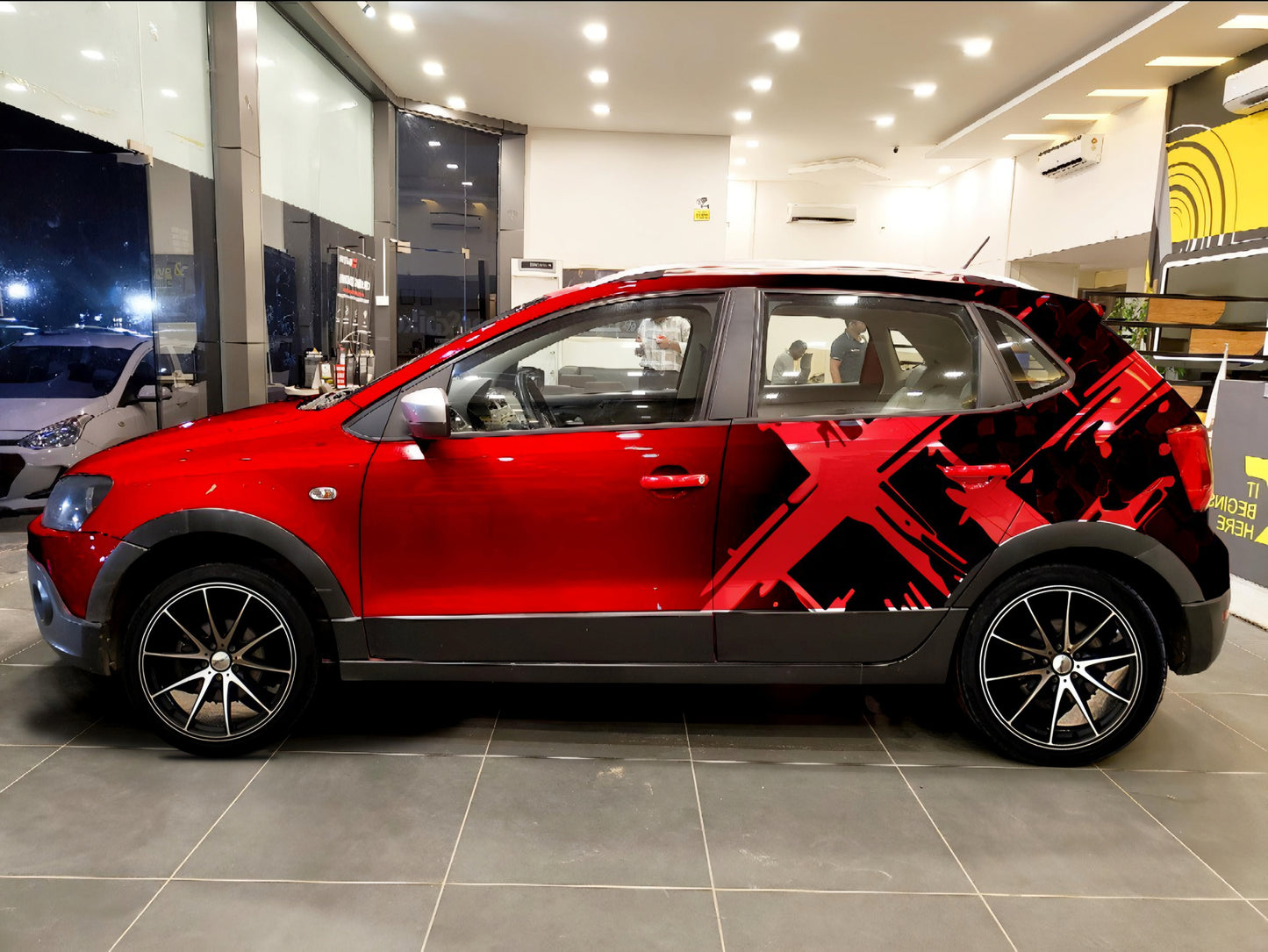 Car featuring Motorik Multi-X graphics in bold red and black design with stylish alloy wheels