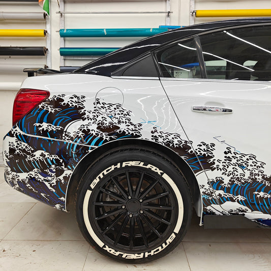 Ocean theme car sticker featuring colorful wave graphics on a sleek sedan