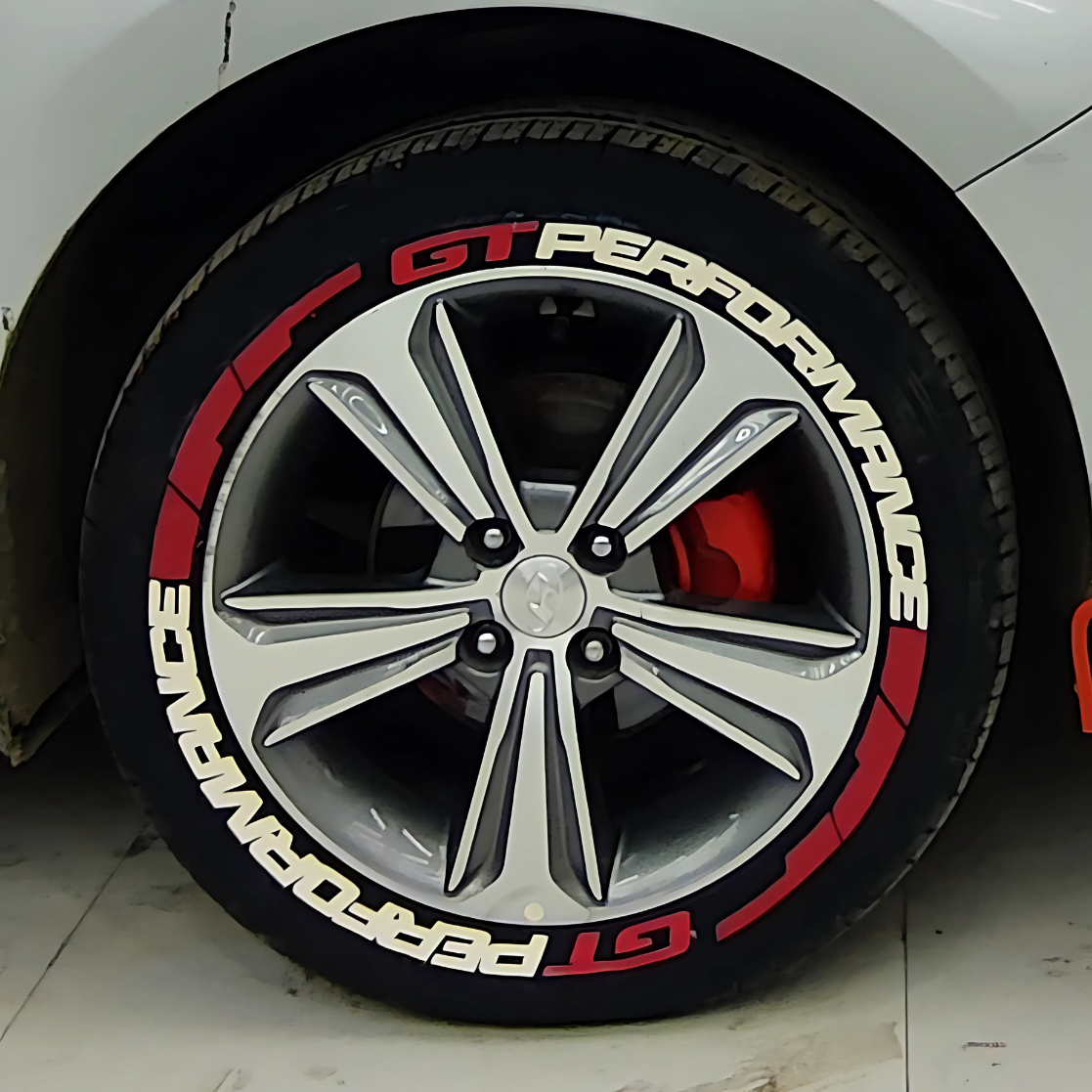 Performance tire decals set with striking red design on alloy wheel for enhanced vehicle aesthetics