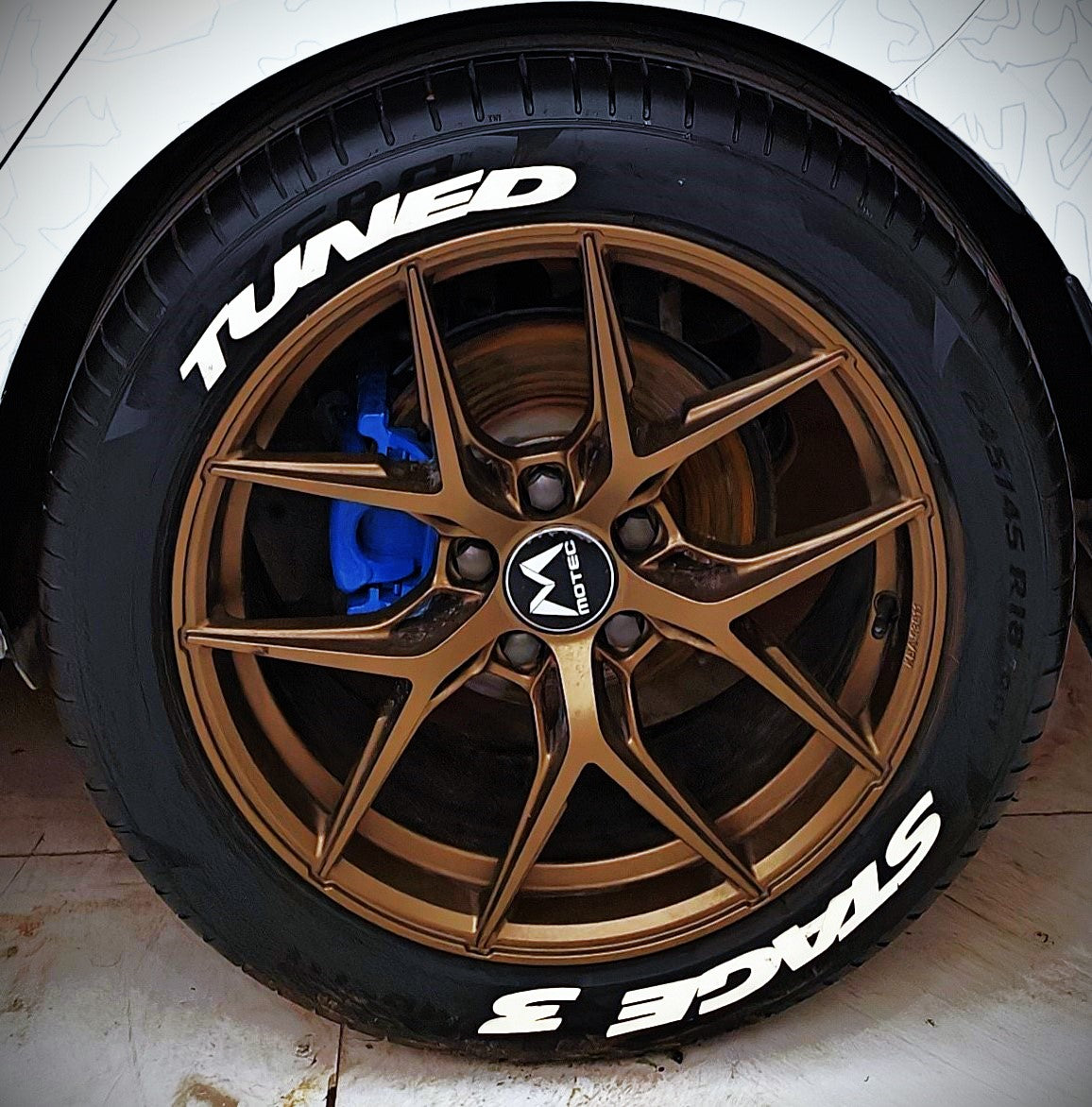 Permanent Tyre Stickers Kit on a bronze alloy wheel with a white lettering design