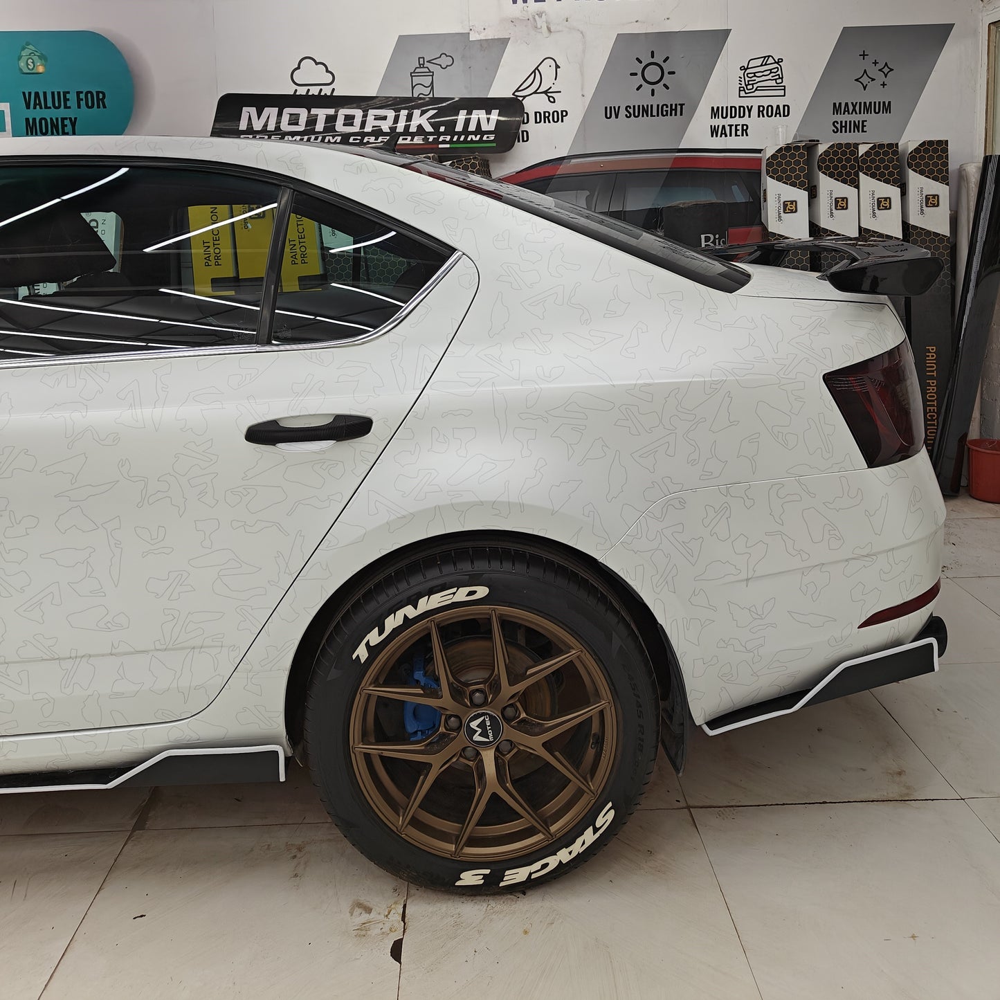 Permanent Tyre Stickers Kit on a white car with stylish wheels and detailed design for enhanced appearance