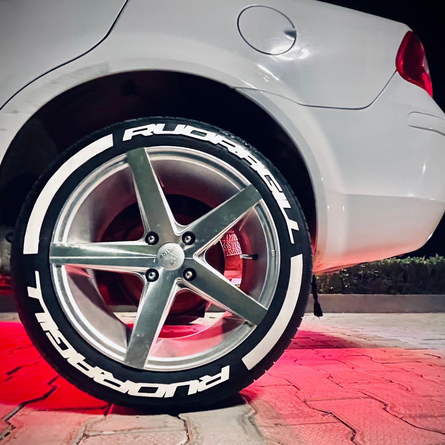 Permanent Tyre Stickers Kit on a stylish car wheel with bold lettering for enhanced aesthetics