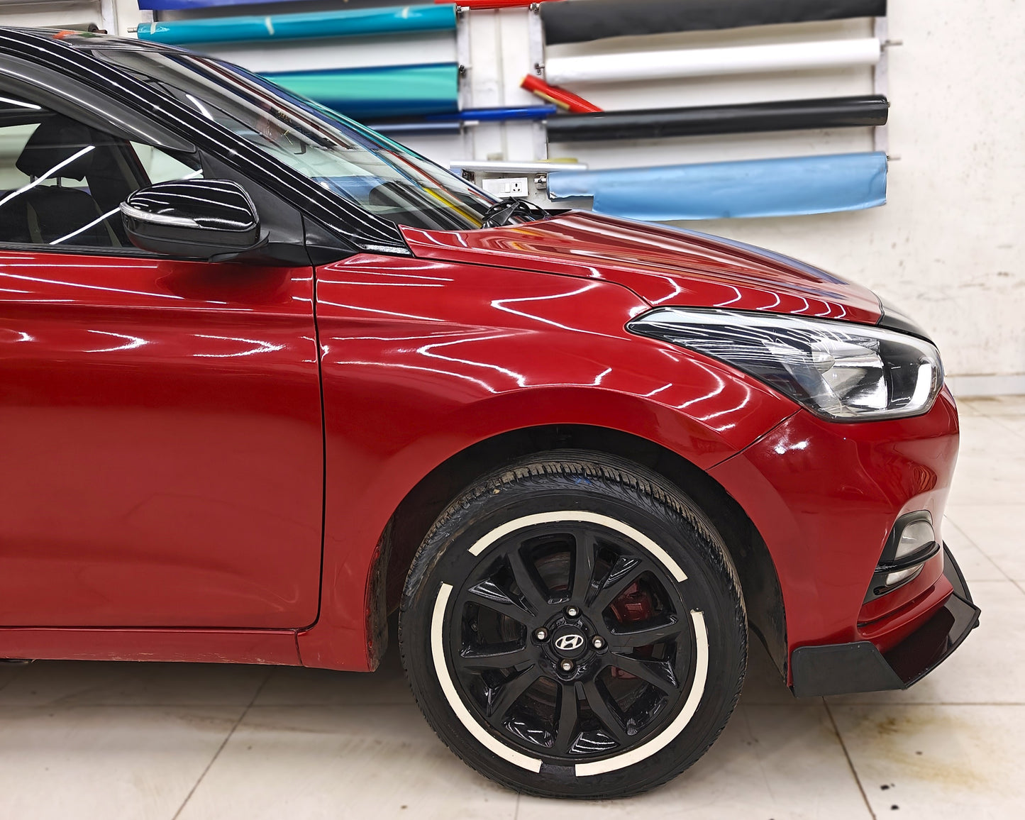 Red car featuring Motorik Detailing permanent rubber tyre stickers on black alloy wheels