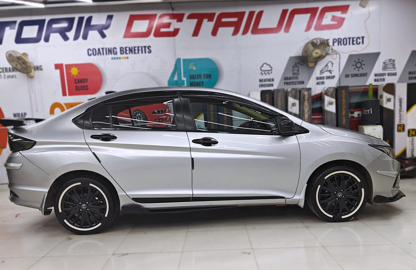 Silver car with permanent rubber tyre stickers highlighting sleek design and detailing at Motorik Detailing