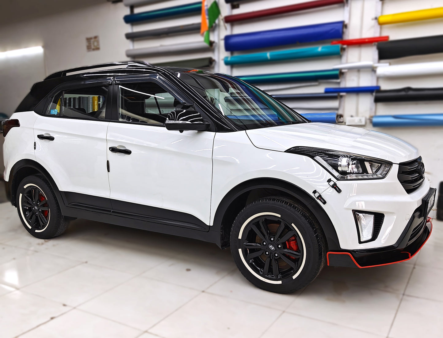 Permanent rubber tyre stickers on a white SUV with black alloy wheels and red accents