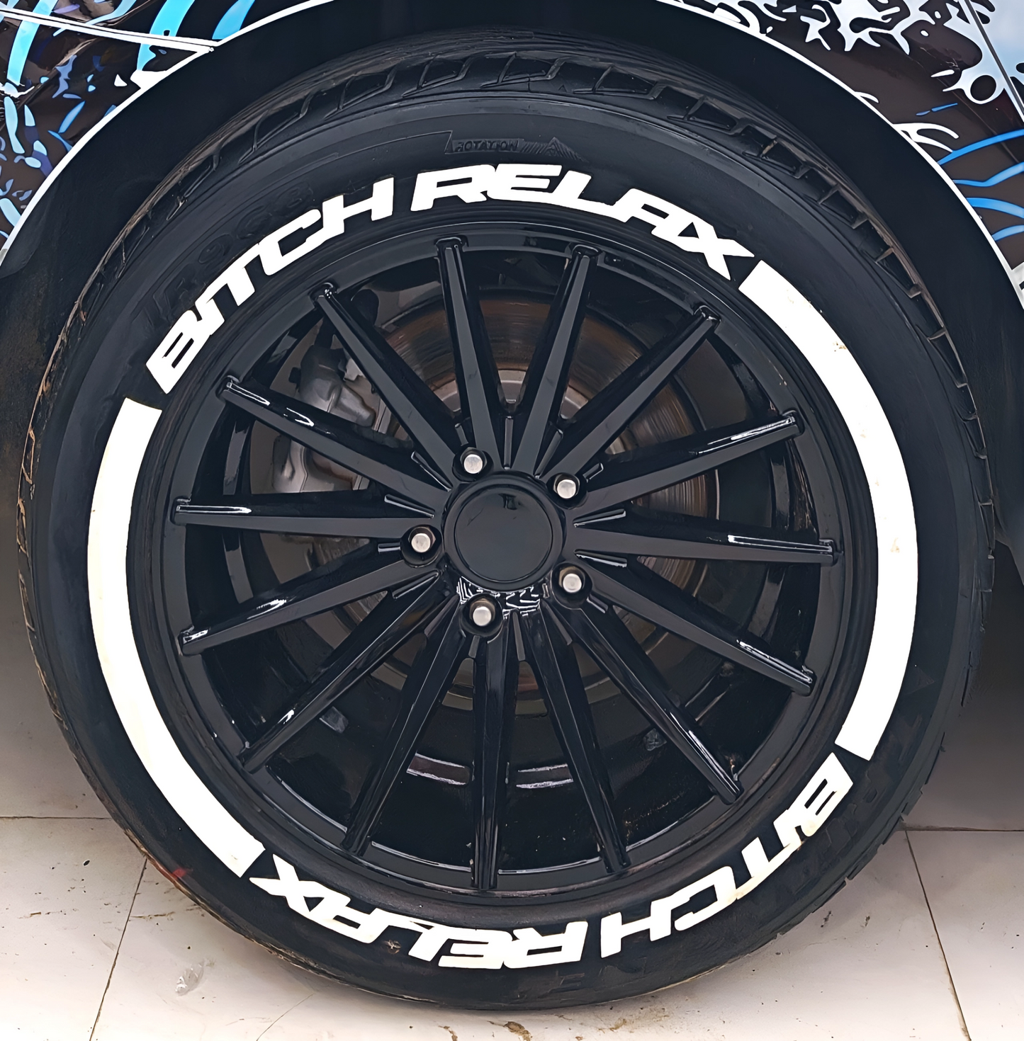 Black alloy wheel with BIT*CH RELAX(W) tyre sticker for stylish car customization