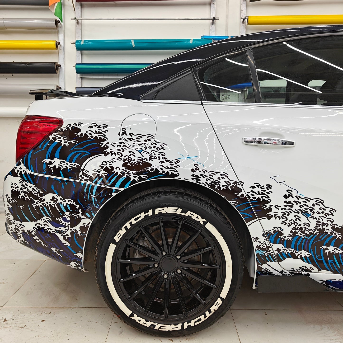 BIT*CH RELAX(W) tyre sticker featured on a stylish car with wave graphics