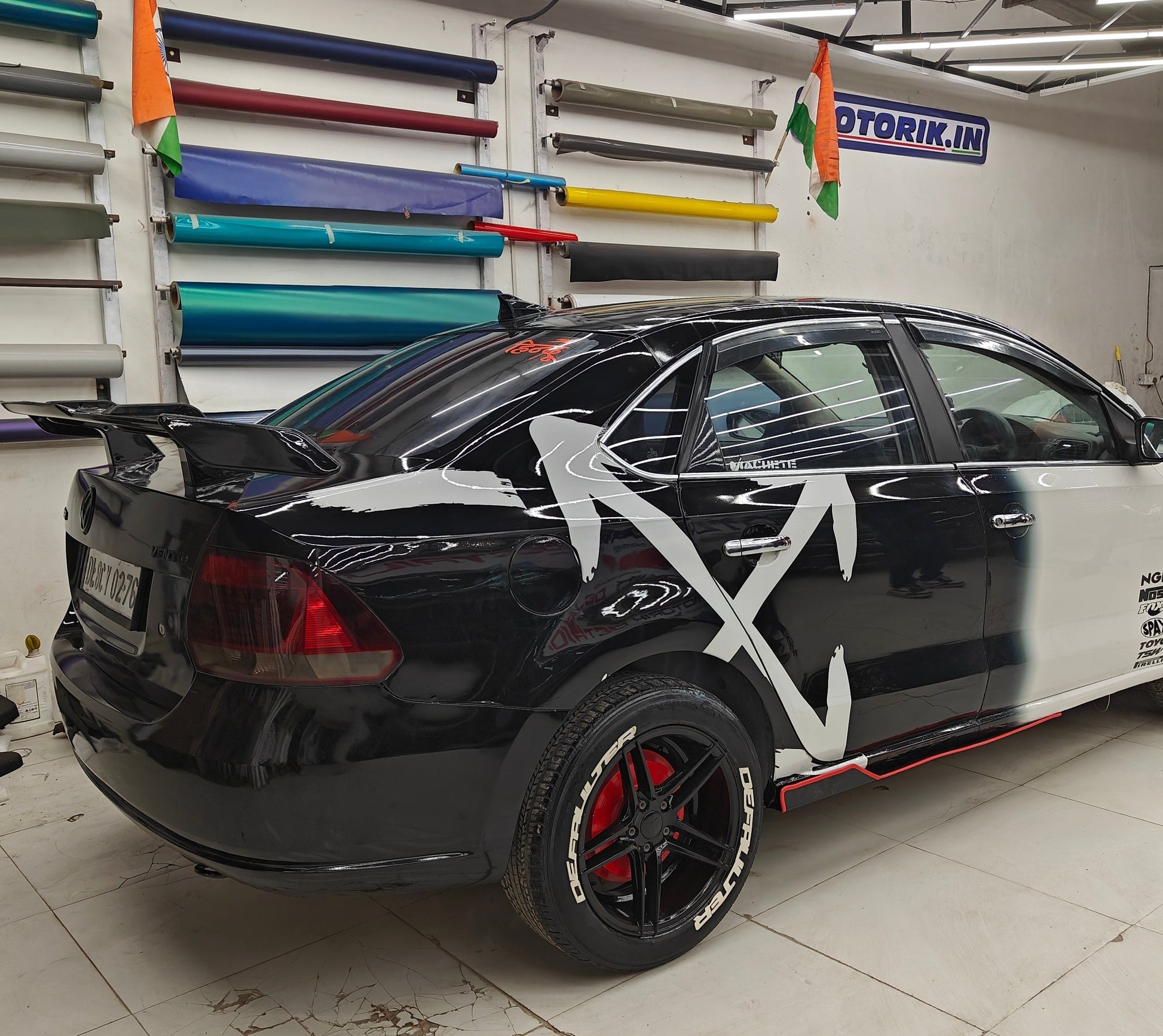 ARROW X car graphics on a black sedan, showcasing a sleek design with bold white elements