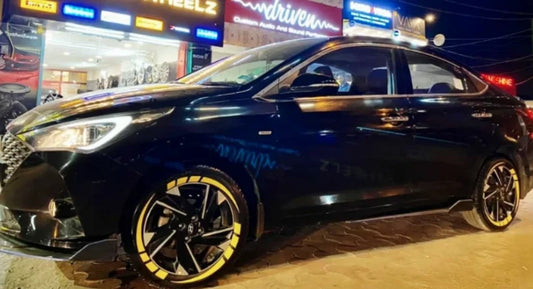 Black car featuring striking TYRE STICKER as stylish car wheel accessories in India