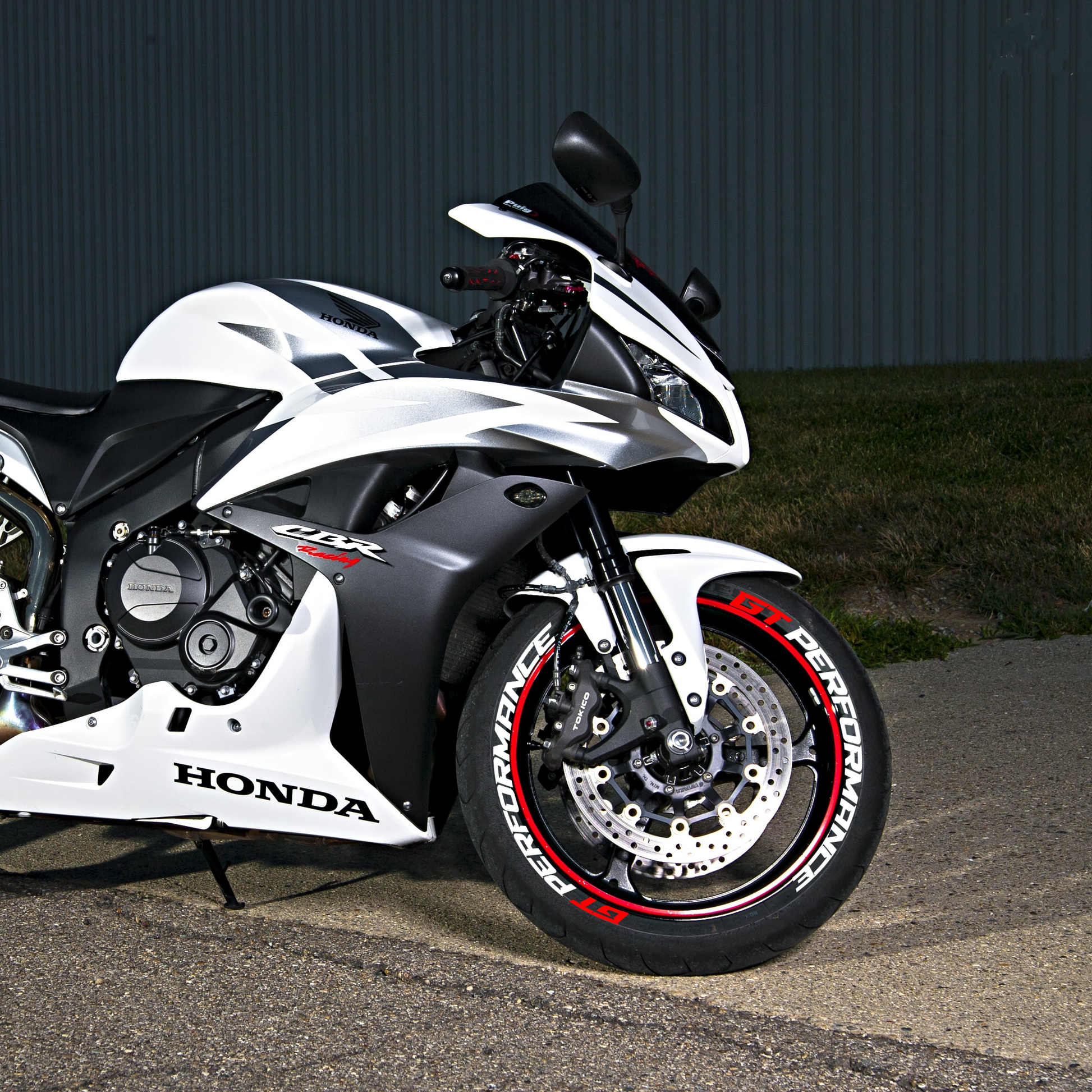 Honda sports bike with GT-PERFORMANCE bike tire sticker on the front wheel in a sleek design