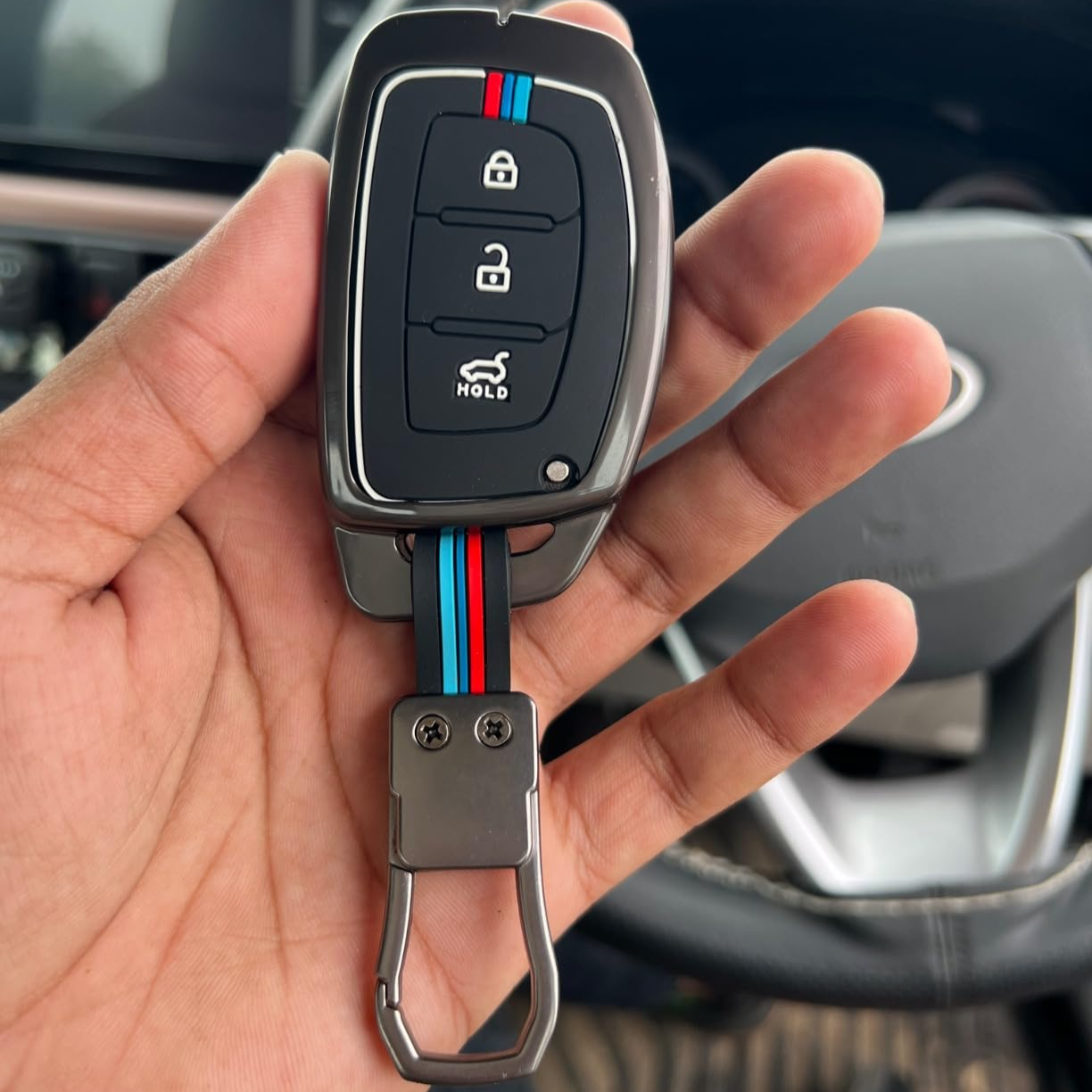 Hyundai 3-Button smart key cover black displayed in hand with sleek design and vibrant accents