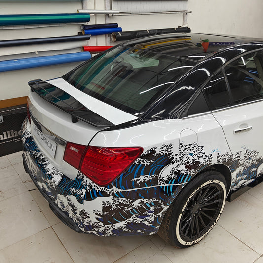 Sedan car with ocean theme car sticker featuring vibrant waves and sleek design by Motorik Detailing